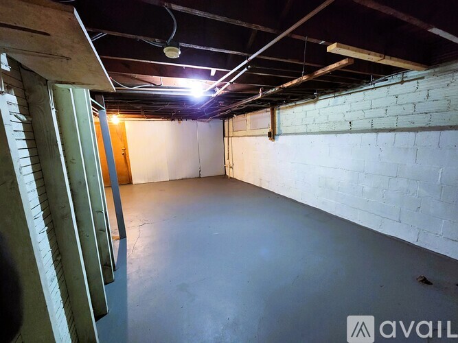 A spacious empty room with a concrete floor and white brick walls.