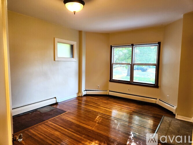 A room with a window and a picture frame on the wall.