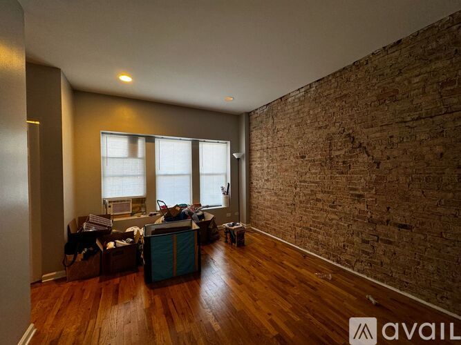 A room with a brick wall and wooden floors.