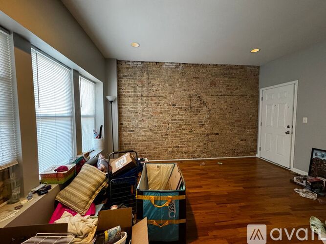 A room with a brick wall and a lot of clutter.