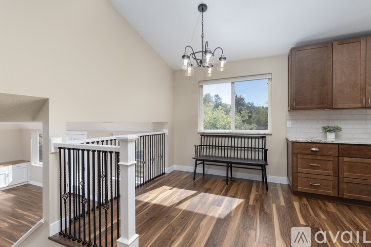 A spacious room with a balcony and wooden flooring.