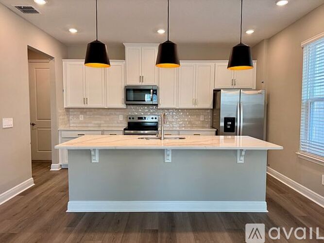 A kitchen with a white island and a refrigerator.