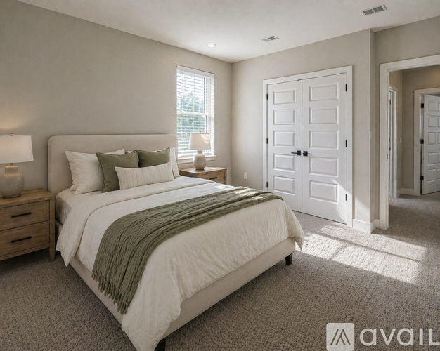 A bedroom with a large bed and a window.