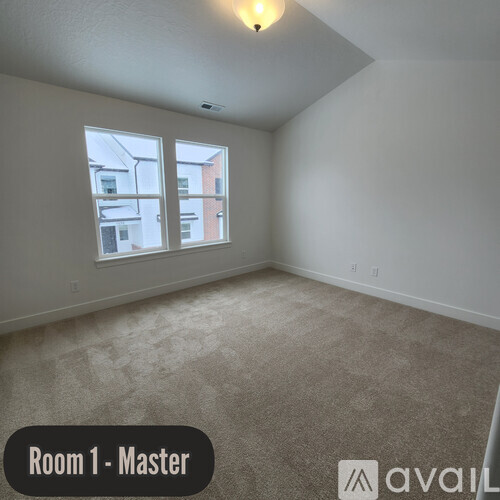 A room with a window and a carpeted floor.
