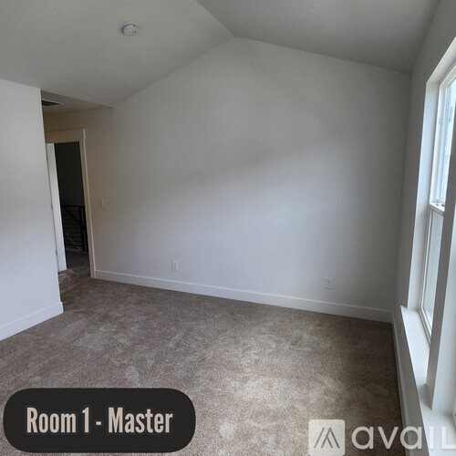 A room with a carpeted floor and a window on the right side.