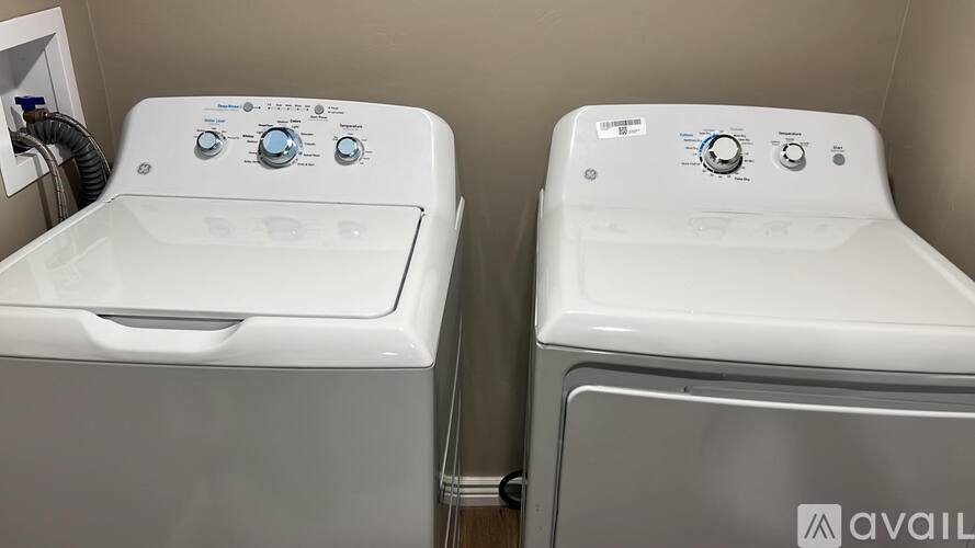 Two white front loading washing machines in a laundry room.