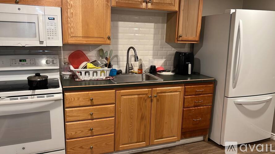 A kitchen with wooden cabinets and a white refrigerator.
