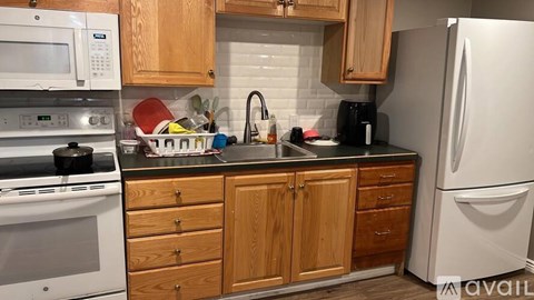 A kitchen with wooden cabinets and a white refrigerator.