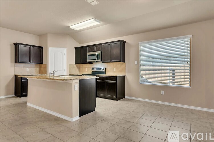 A kitchen with black cabinets and a white countertop is available.
