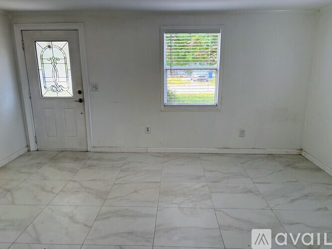 A room with a marble floor, a door, and a window with blinds.