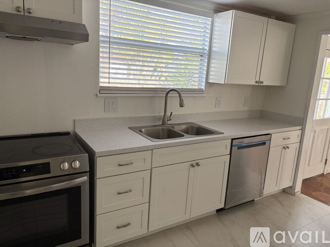 A kitchen with white cabinets and a stainless steel dishwasher.