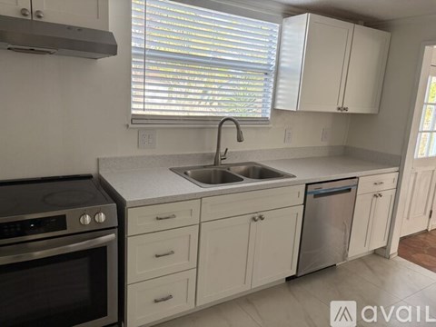 A kitchen with white cabinets and a stainless steel dishwasher.