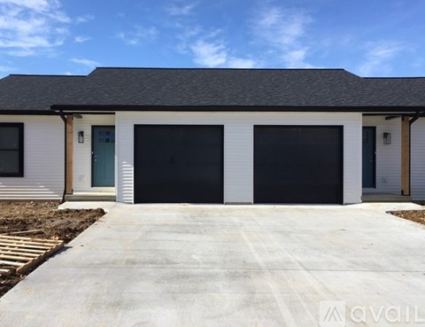 A two-car garage with a white exterior and black roof.