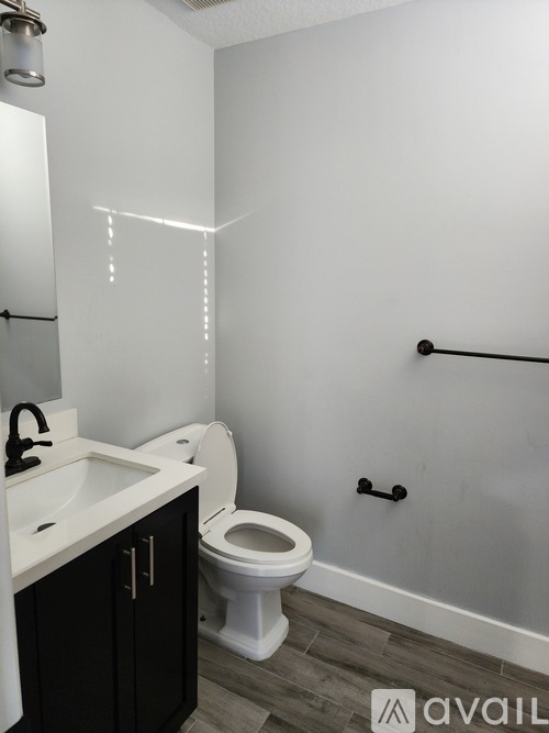 A bathroom with a toilet, sink, and a mirror.