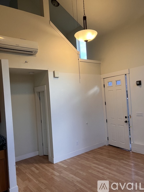 A room with a white door and a wooden floor.
