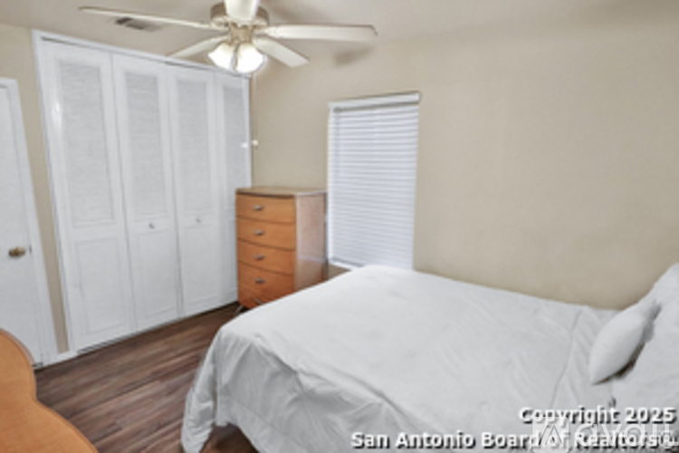 A bedroom with a bed, dresser, and closet.