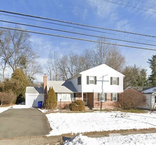 A house with a white roof and a driveway in front.