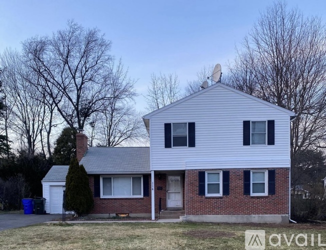A house with a white siding and a brick foundation is for sale.