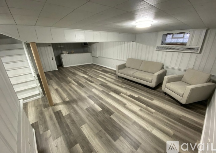 A living room with a couch and a staircase.