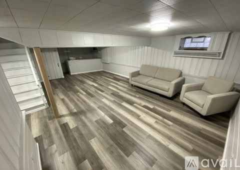 A living room with a couch and a staircase.