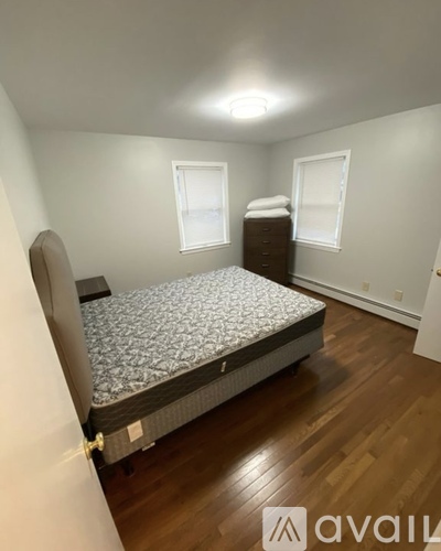 A bedroom with a bed, dresser, and window.