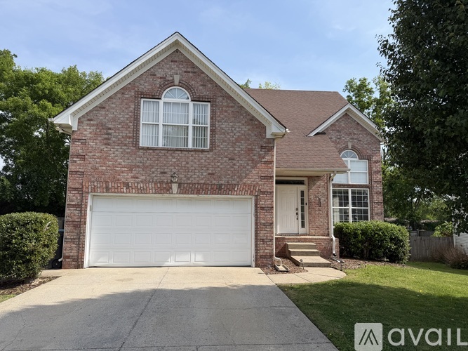 A house with a brick facade and a white garage door is shown.