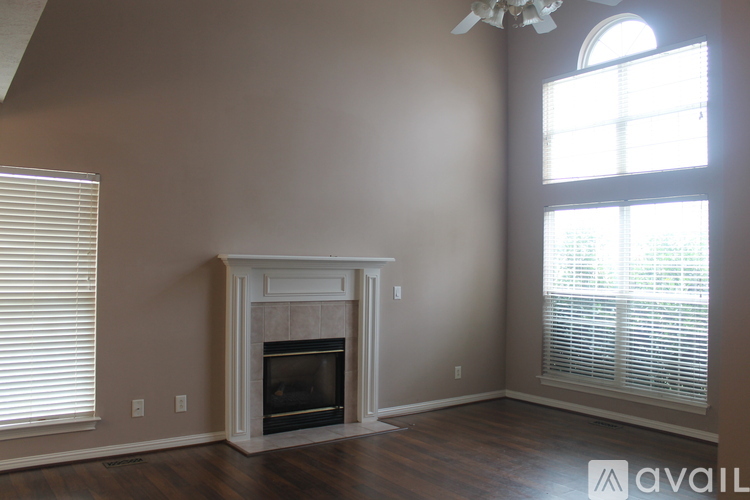 A living room with a fireplace and a fan.