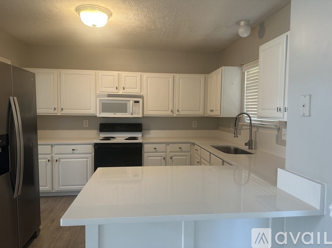 A kitchen with white cabinets and appliances.