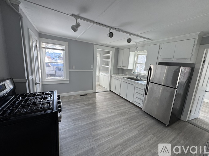 A kitchen with a black stove top oven and a refrigerator.