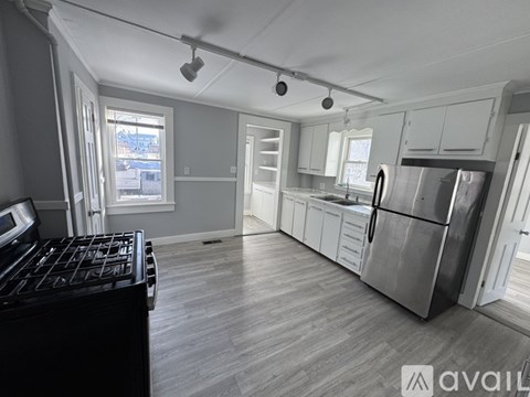 A kitchen with a black stove top oven and a refrigerator.