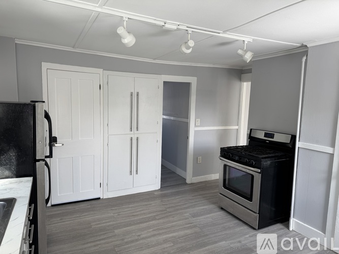 A kitchen with black appliances and white cabinets.