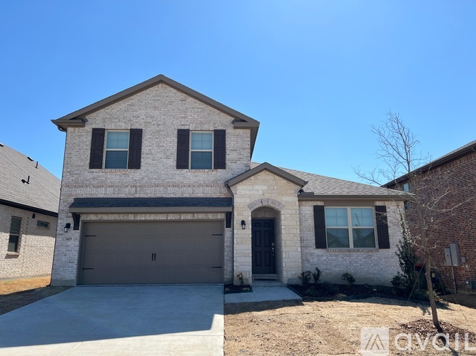 A two-story house with a garage and a driveway.