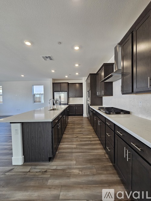A modern kitchen with dark wood cabinets and a white countertop.