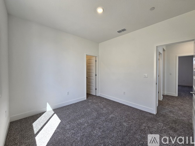 A spacious room with a carpeted floor and white walls.