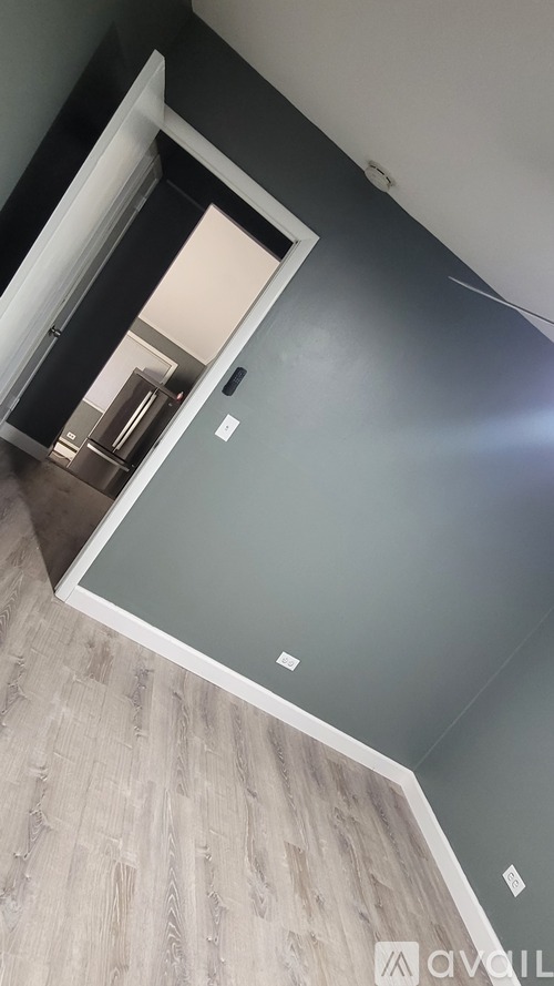 A white door is open to a room with a grey wall.