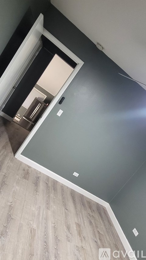 A white door is open to a room with a grey wall.
