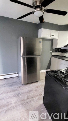 A modern kitchen with a stainless steel refrigerator and a black stove.