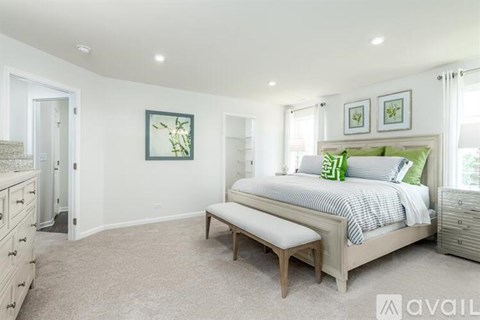A bedroom with a bed, bench, and two pictures on the wall.