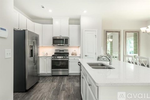 A modern kitchen with white cabinets and stainless steel appliances.