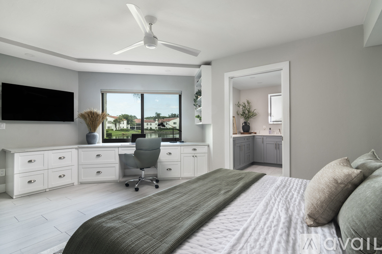 A bedroom with a large bed and a desk with a chair.
