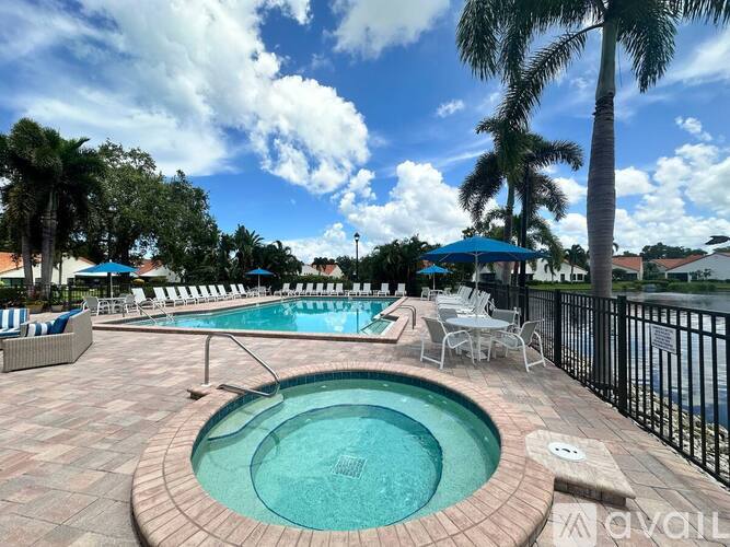 A pool area with a hot tub and chairs.