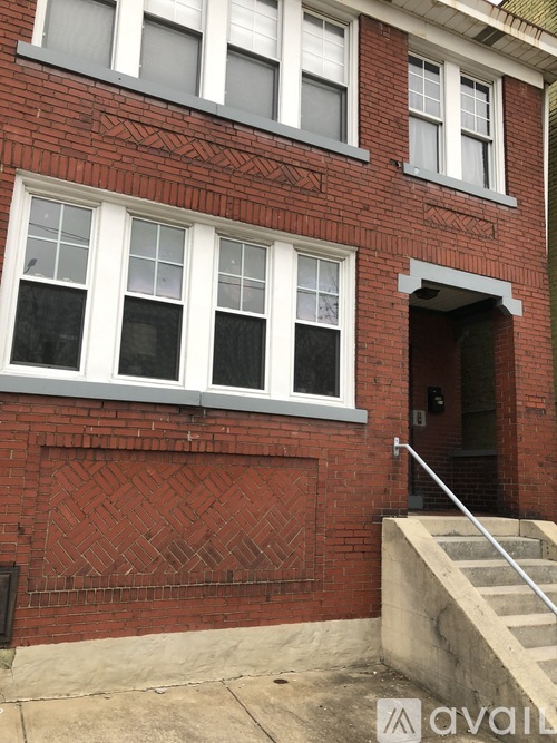 A red brick building with a white door and windows.