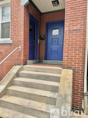 A blue door is on the right side of a brick building.