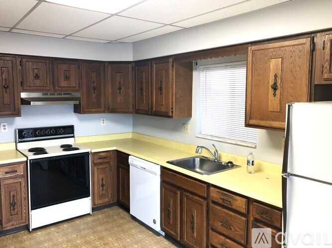 A kitchen with wooden cabinets and white appliances.