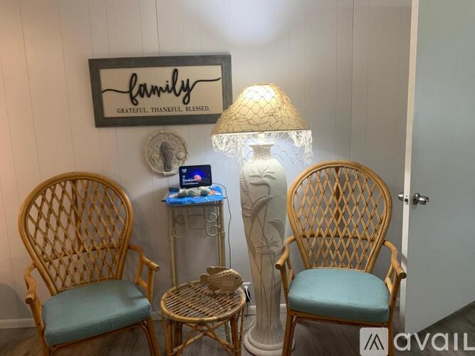 Two chairs and a table with a lamp on it.