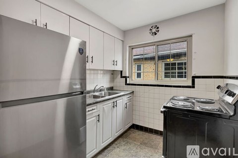 A kitchen with a stainless steel refrigerator and a black stove top oven.