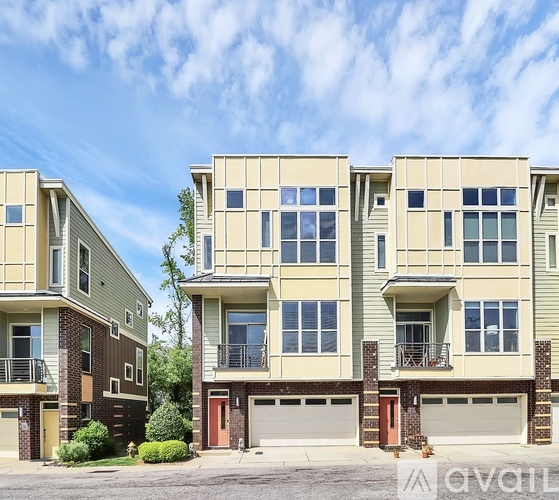 A row of modern townhouses with balconies and garages.