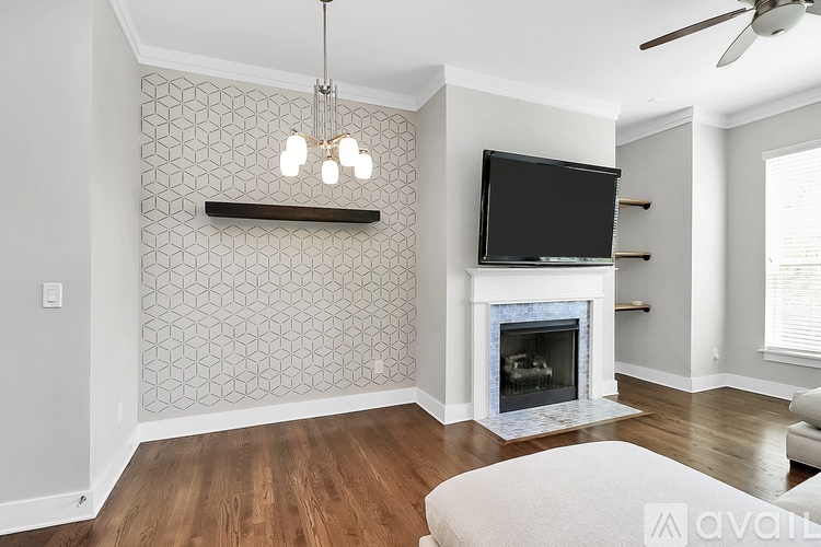 A living room with a fireplace and a television mounted above it.