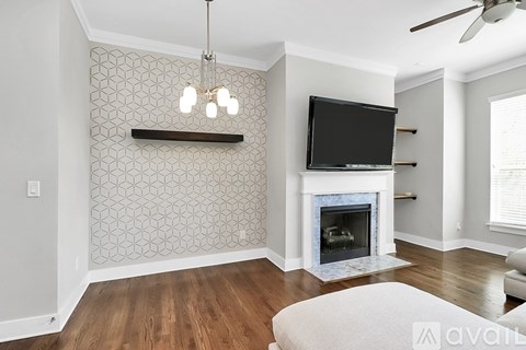 A living room with a fireplace and a television mounted above it.