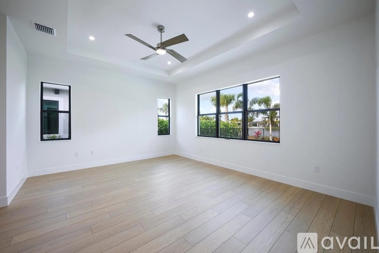 A spacious room with a ceiling fan and wooden flooring.